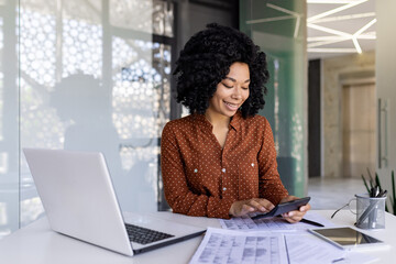 Successful happy accountant financier with a calculator prepares a financial report and fills in...