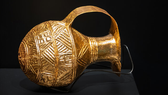 Canakkale, Turkey - Nov 19, 2023 bronze-gold mixed wine jug from the bronze age with reliefs on a black background. Exposition of ancient art at the Archaeological Museum