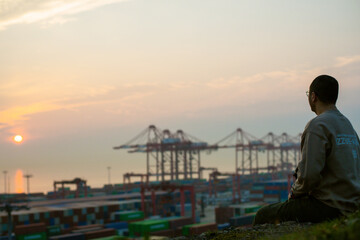 Yangshan Port, Zhoushan City, Zhejiang Province - People sitting on the dock at sunset