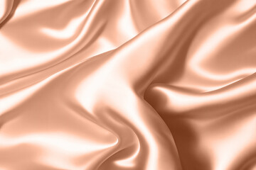 Obraz premium Abstract background, folds of silk fabric in peach fuzz color.