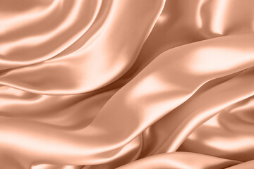 Fototapeta premium Abstract background, folds of silk fabric in peach fuzz color.