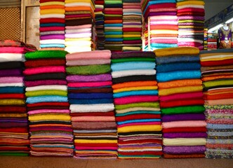 Piles or bolts of bright fabric in a Hanoi market