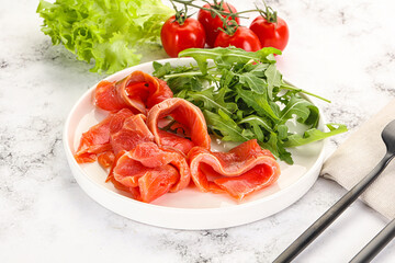 Sliced salmon with fresh arugula
