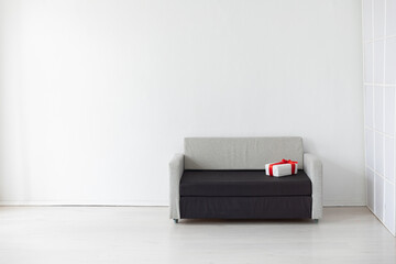 grey office sofa with holiday gifts in white room interior