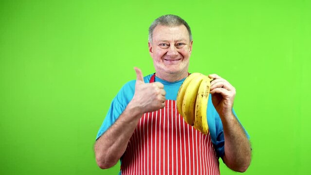 Senior cook pointing finger at stem bananas.