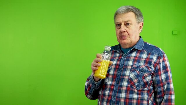 Senior man is thirsty and drinks orange juice.
