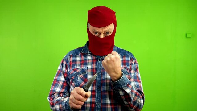 Dangerous criminal in mask threatening with knife.