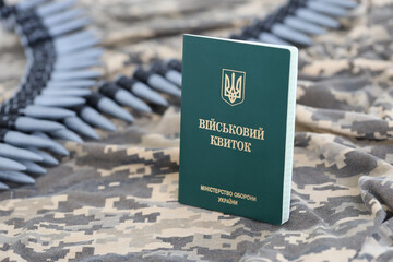 Ukrainian military ID on fabric with texture of pixeled camouflage. Cloth with camo pattern in...