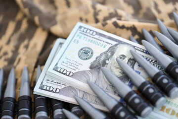 Bundles of dollars and a machine gun belt on the camouflage uniform of a Ukrainian soldier. Concept...