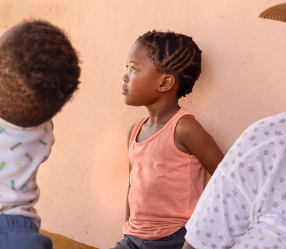 Small African Girl With Braids Hairstyle Together With The Family In Front Of The House