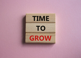 Time to Grow symbol. Concept word Time to Grow on wooden blocks. Beautiful pink background....