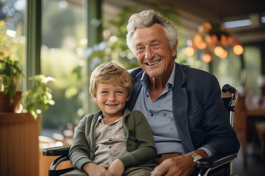 Smiling elderly man with a kid in wheelchair in retirement home. Disability situation. Someone with reduced mobility.