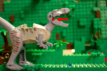 Close-Up of Interlocking Brick Dinosaur Toy Against Green Block Background