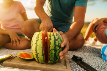 close up of a man cutting a watermelon