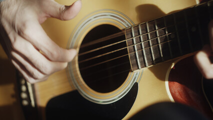 Close-up of man playing acoustic guitar with right hand