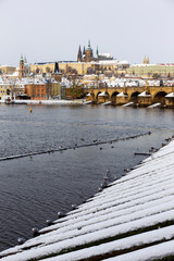 Snowy Prague Lesser Town with Prague Castle and Charles Bridge above River Vltava in the sunny Day , Czech republic