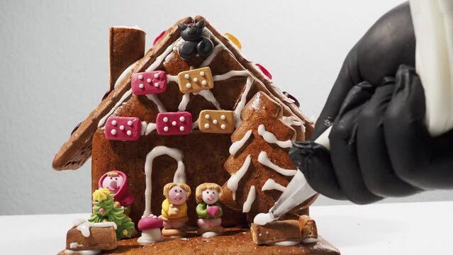 Christmas gingerbread in the shape of a house. Assembling a gingerbread house before Christmas with sugar icing.