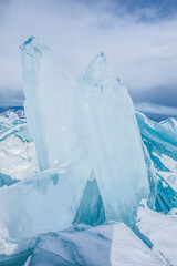 Large transparent turquoise ice floes on frozen Baikal lake in winter day