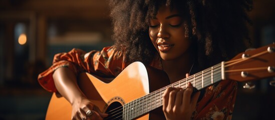 Cropped a curly young woman guitarist enjoy playing guitar in home - obrazy, fototapety, plakaty