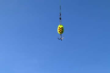 Fishing hook with bait. Close up and isolated. Blue sky.