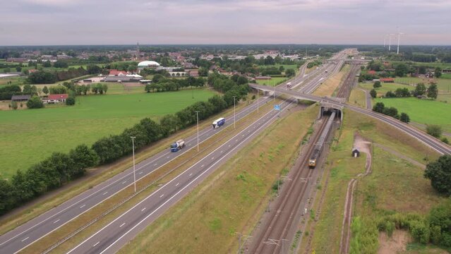 This panoramic aerial footage captures the sprawling expanse of a highway interchange with its intricate network of roads, illustrating the intersection between rural tranquility and modern