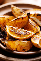Close-up view of grilled lemon pieces-wedges, focus on the lemon inside. Perfect addition to dishes and an ingredient of delicious lemonade made from grilled lemons.