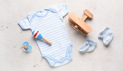 Baby clothes and accessories on light background