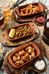 Crunchy fried squid rings breaded, fried anchovies in cornmeal, fried dumplings and glasses of beer...