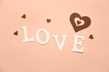 Word love from paper letters and red hearts. Peach fuzz is color of year 2024.