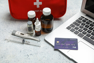 Laptop, credit card and first aid kit on grunge white background