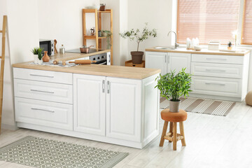 Interior of light kitchen with white counters and carpets