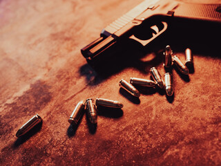 Hand gun with ammunition on dark background. 9 mm pistol military weapon and pile of bullets ammo...