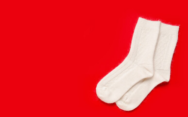 White knitted socks on red background
