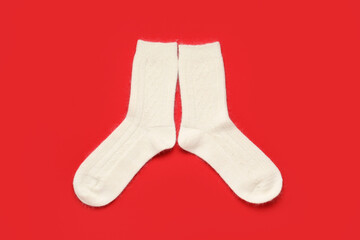 White knitted socks on red background