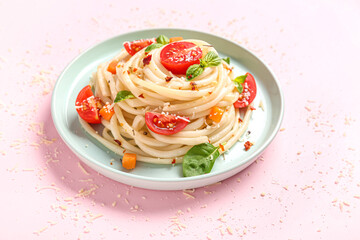 Plate with tasty pasta primavera on pink background