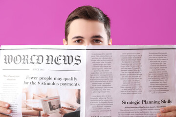 Young man reading newspaper on purple background, closeup