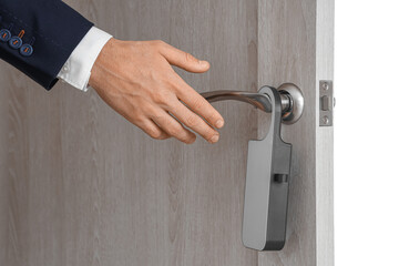 Businessman opening door with hanger in hotel room, closeup