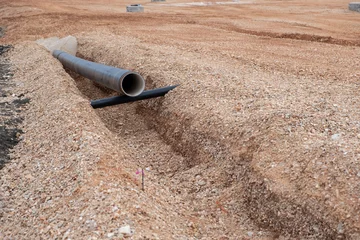 Foto op Canvas Laying sewer drainage pipe on constriction site. Digged New sanitary sewer, storm drain systems © ArieStudio