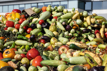 Heap of Mix expired Vegetables and fruits at harvest time. Organic bio waste in a huge container,...