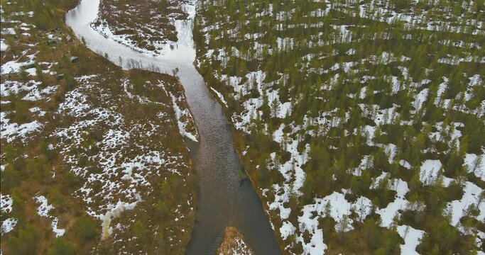 Aerial landscape view of Sotajoki river in cloudy spring weather with snow on the ground, Sodankylä, Lapland,  Finland.