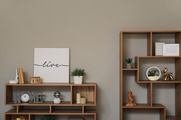 Shelf units with stylish decor near light wall