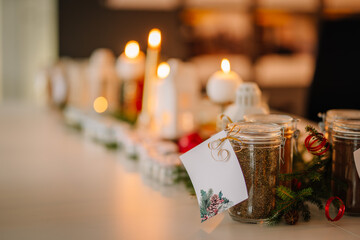 Vintage Christmas background. Christmas candle lantern on rustic table with fir branch, pine cone and christmas decoration against winter window. Morning, magic light.