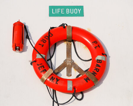 Port Jefferson, Long Island, New York - USA: Bright orange life buoy hanging on the wall of the P. T. Barnum ferry