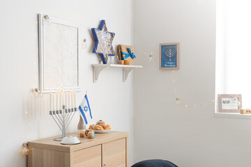Wooden cabinet with traditional Hanukkah decorations in festive living room