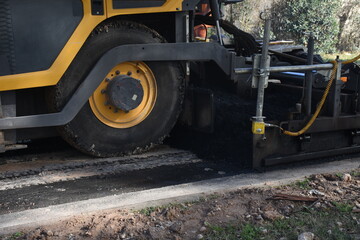 Machine paving a road