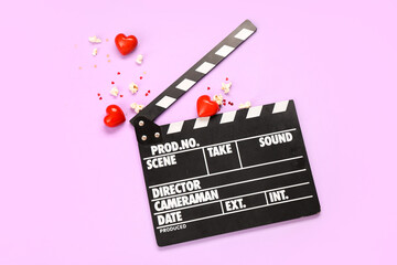Movie clapper with popcorn, confetti and hearts on lilac background. Valentine's Day celebration