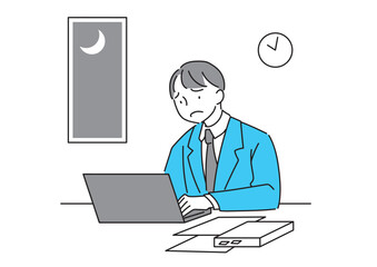 遅い時間まで残業するスーツの男性