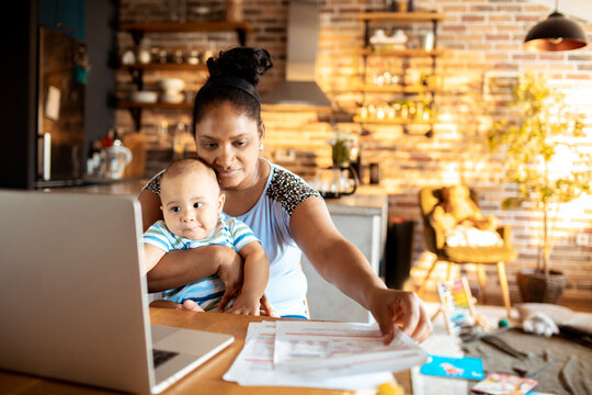 Mother working in home office with baby