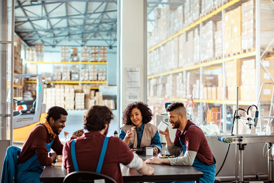 Diverse warehouse workers eating together