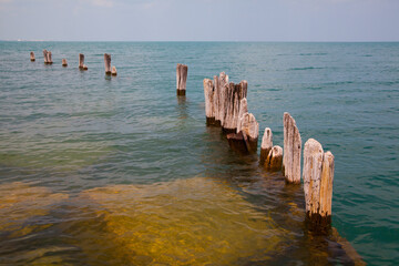 Serene Coastal Landscape with Weathered Wooden Posts in Clear Waters